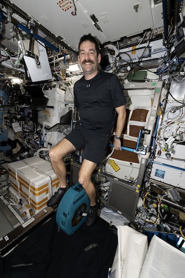 NASA astronaut Jack Hathaway pedaling on the exercise cycle inside the International Space Station’s Destiny laboratory module