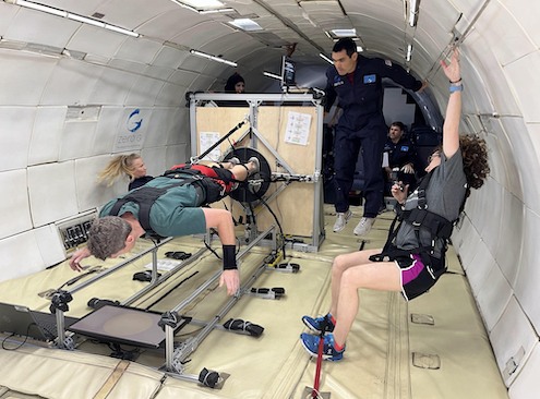 A multidisciplinary NASA team collaborates during a parabolic flight to evaluate an advanced exercise countermeasure device.